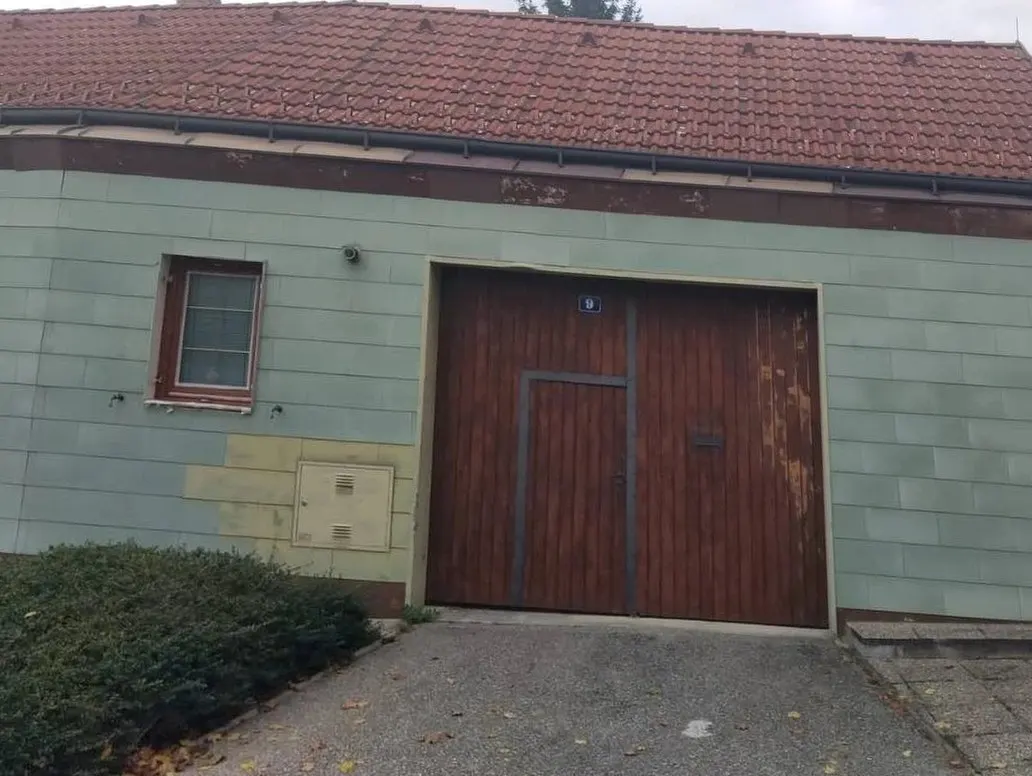 Vorher: Hausfassade vor der Sanierung: fleckiger Altanstrich, verwittertes Holztor