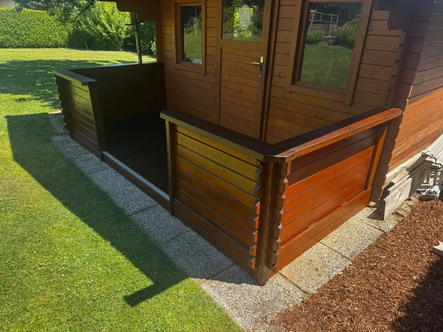 Gartenhaus mit Terrasse nach der Lasur: Wände und Brüstung in warmem Braun