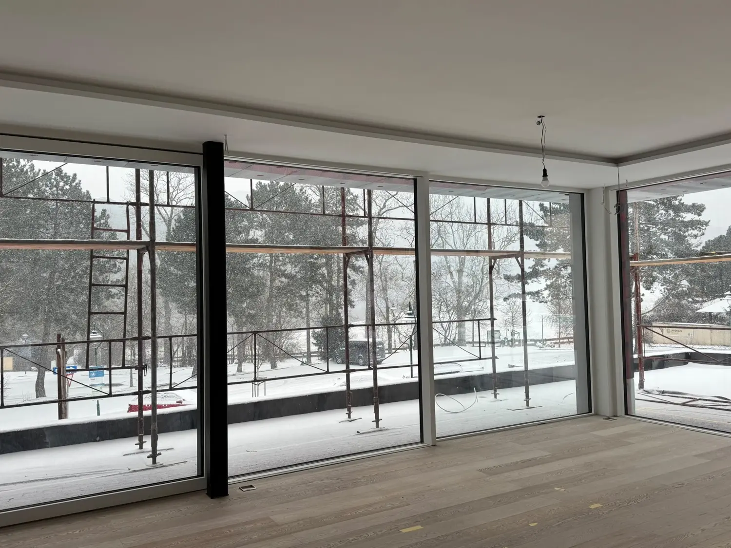 Fertiger Raum mit Glasfront, weißer Decke und Holzboden