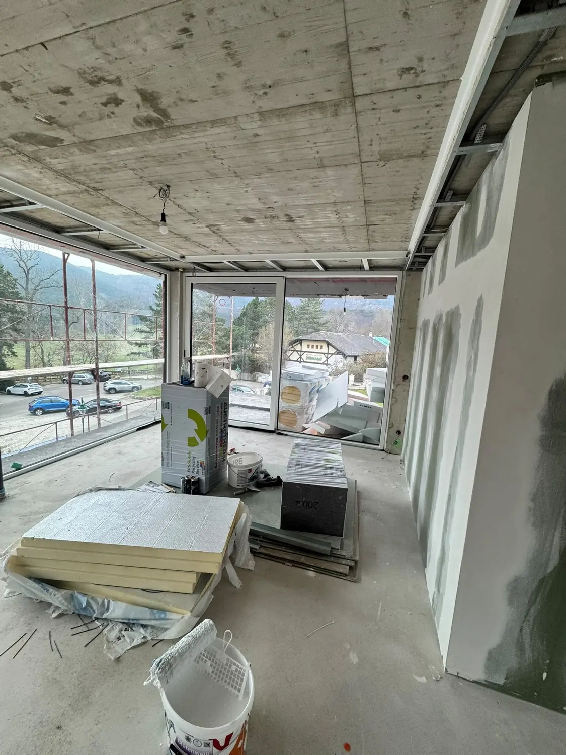 Neubau im Rohzustand: Betondecke, Dämmplatten und Material am Boden