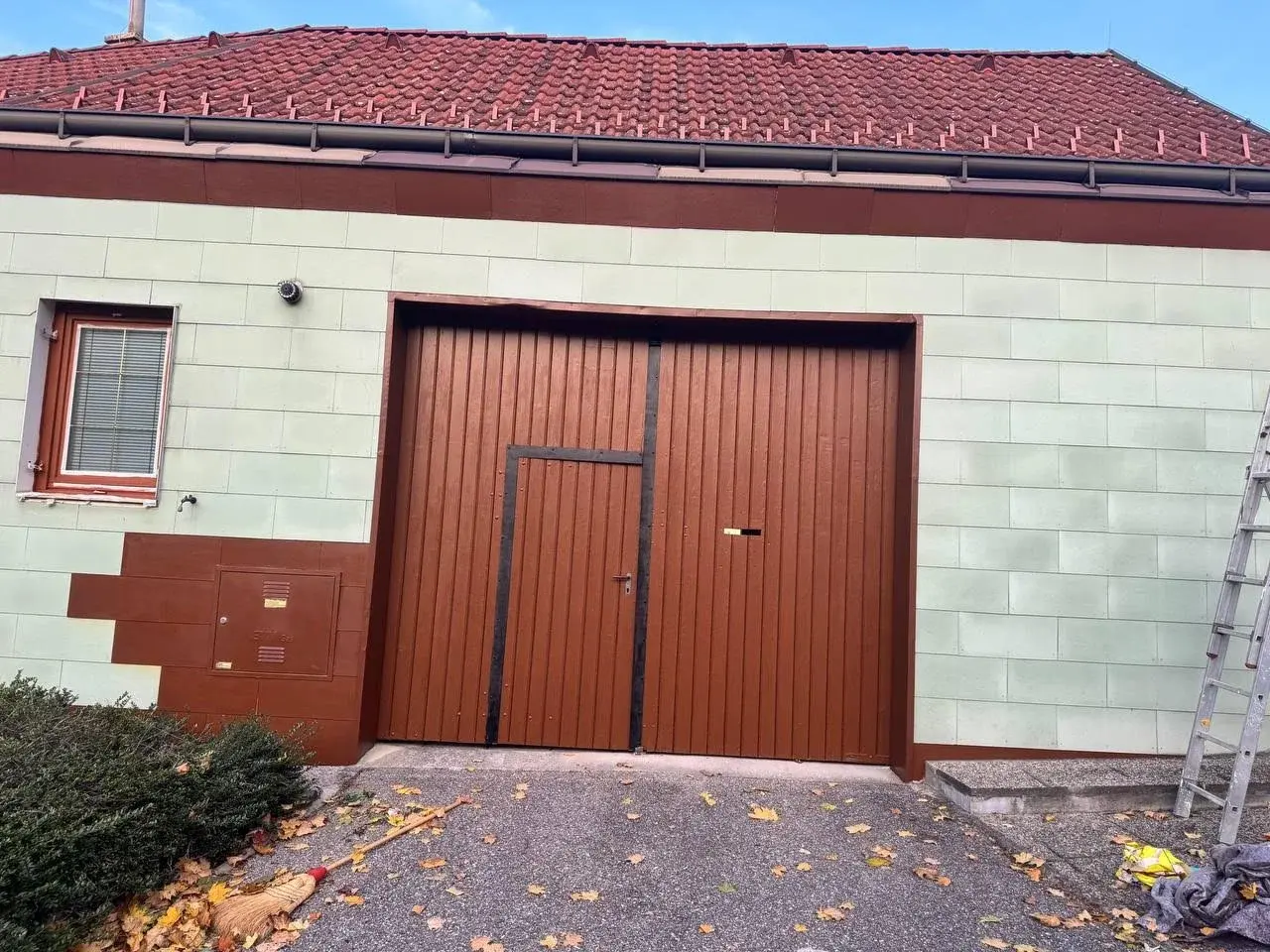 Nahaufnahme der sanierten Fassade mit lackiertem Tor